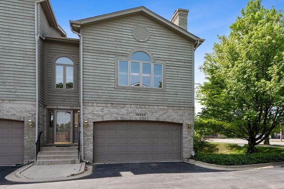 Front view of a house with two garages and stairs leading to the entrance.