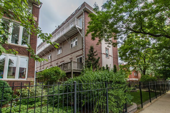 Side view of a multi-story brick building with balconies.