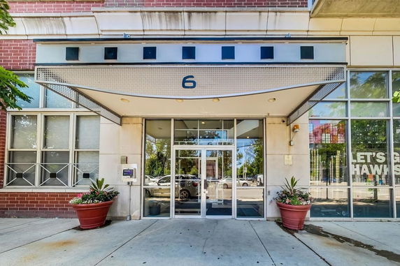 Front view of a building entrance with glass doors and decorative awning.