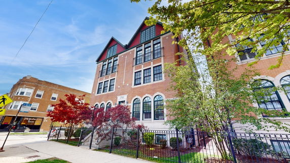 Front view of a multi-story brick building with large windows and a decorative facade.