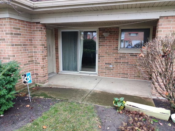 Front view of a house with brick exterior and sliding glass door.