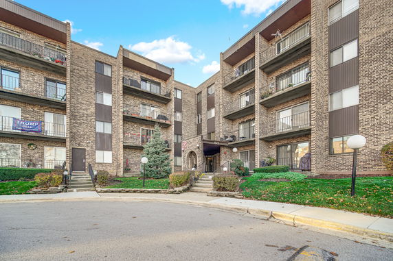 Front view of a multi-story apartment building with balconies.