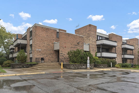 Front view of a multi-story brick building with balconies.