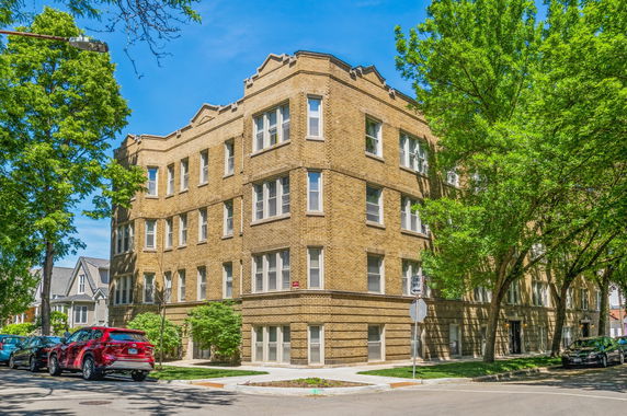 Front view of a multi-story brick building on a corner lot.