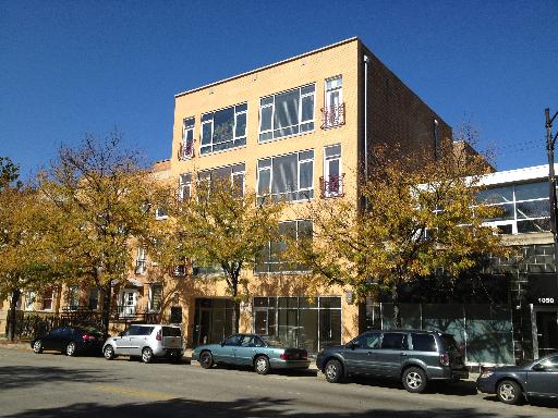 Front view of a multi-story building with large windows and a brick facade.