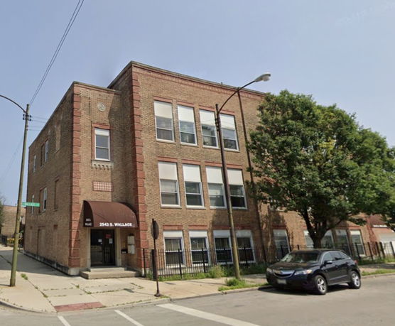 Front view of a multi-story brick building on a corner lot.