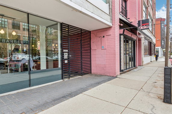 Front view of a commercial building with large glass windows and a pink brick facade.