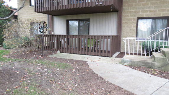 Front view of a two-story building with a patio and balcony.