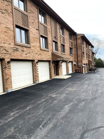 Front view of a multi-story brick building with garage doors.