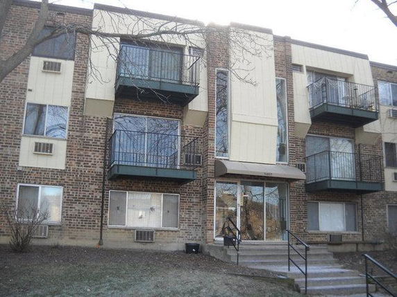 Front view of a multi-story apartment building with balconies.