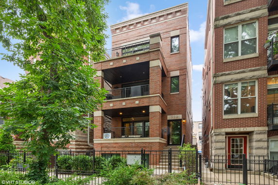 Front view of a brick multi-story apartment building.