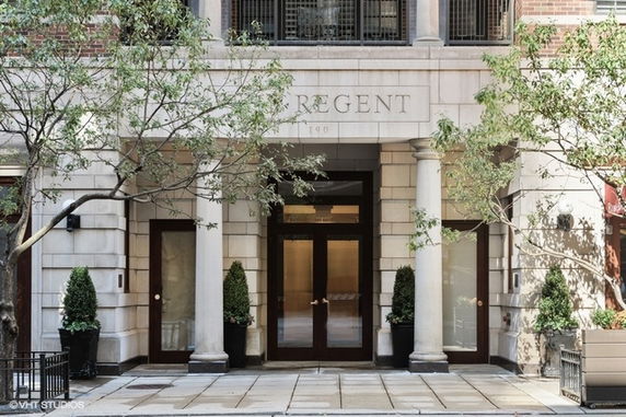 Front view of a building entrance with columns and trees.