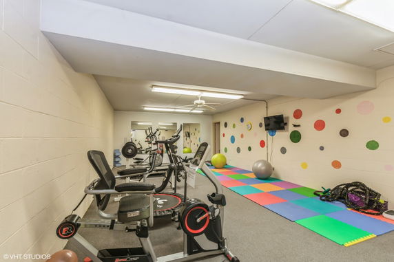 Indoor gym area with exercise equipment and colorful wall decorations.