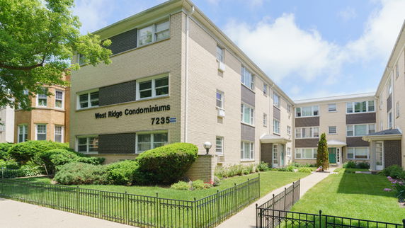 Front view of a multi-story condominium building with the name 'West Ridge Condominiums' displayed on the facade.