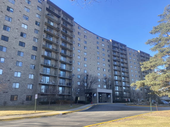 Front view of a multi-story apartment building with balconies.