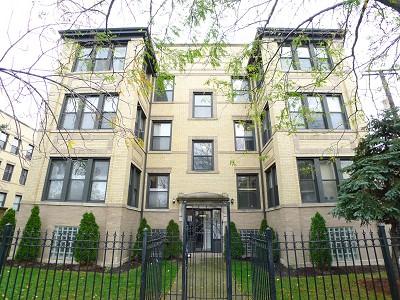 Front view of a multi-story apartment building with a brick facade.
