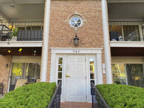 Front view of a two-story building with brick facade and a central entrance.
