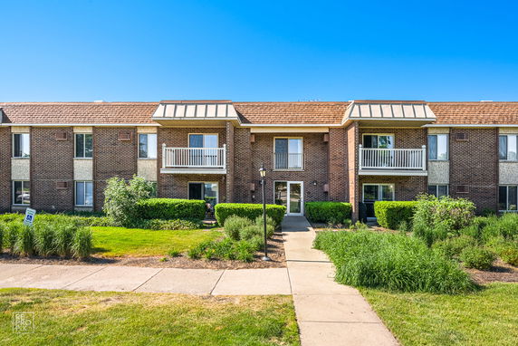 Front view of a two-story brick apartment building with balconies.