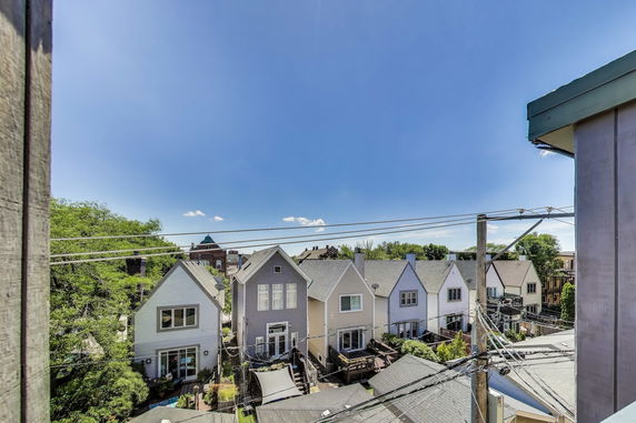 Panoramic view of a row of houses with pitched roofs under a clear blue sky.