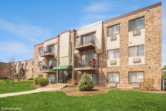 Front view of a multi-story apartment building with balconies.