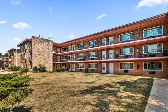 Front view of a three-story apartment building with balconies.