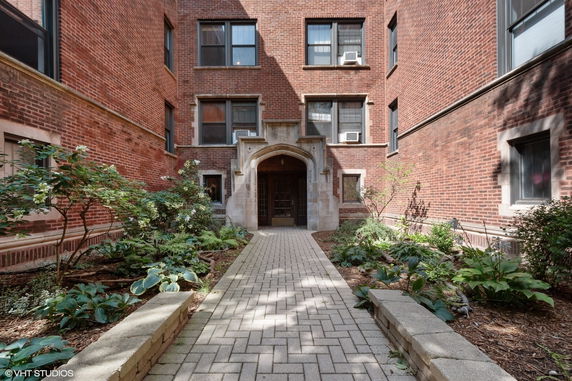 Entrance view of a brick residential building with a central path.