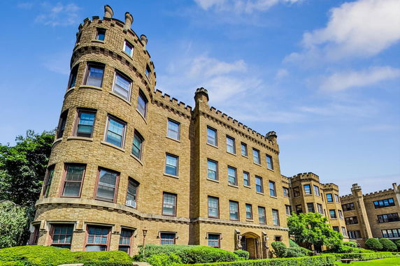 Front view of a historic multi-story brick building with turret features.