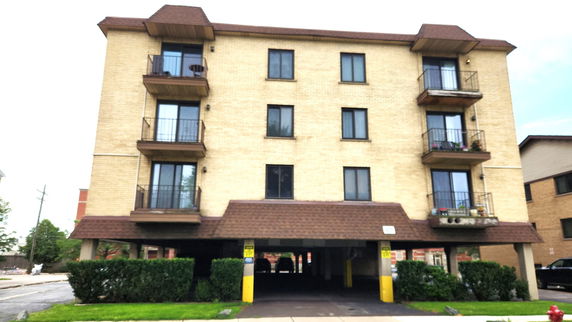 Front view of a multi-story apartment building with balconies.