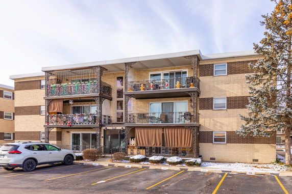 Front view of a three-story apartment building with balconies.