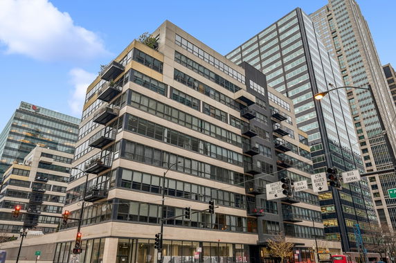 Front view of a multi-story office building with large glass windows and balconies.