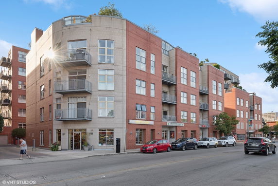 Front view of a multi-story apartment building with several balconies.