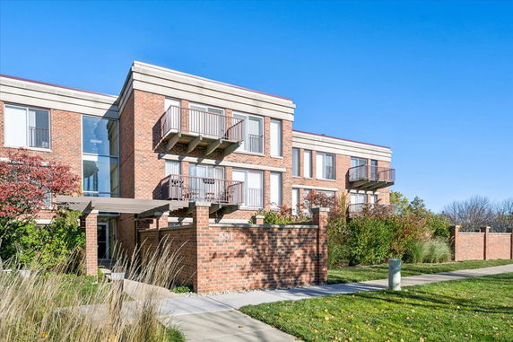 Front view of a brick apartment building with balconies.