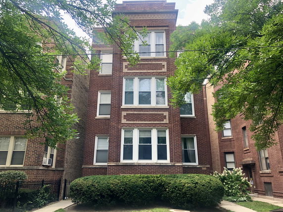 Front view of a multi-story brick apartment building.