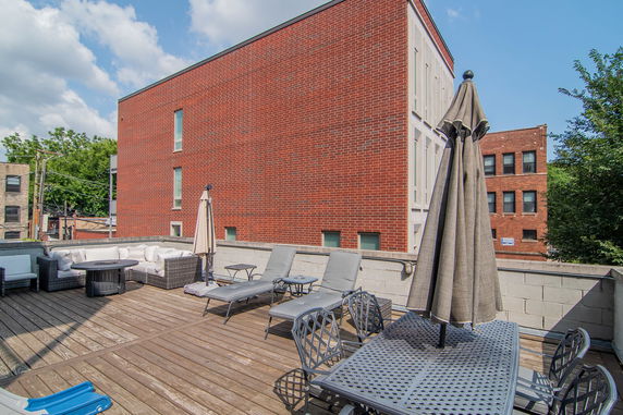Rooftop deck with lounge chairs and an outdoor dining area.