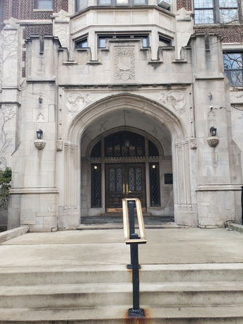 Front view of a historic building with ornate stone entrance and arched doorway.