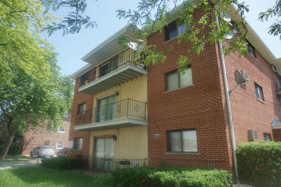 Front view of a multi-story apartment building with balconies.