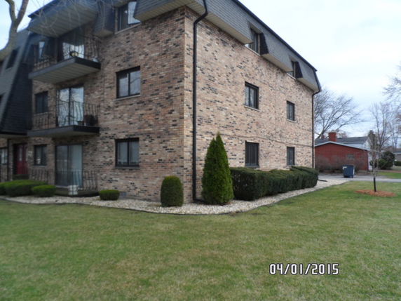 Side view of a three-story brick building with balconies.