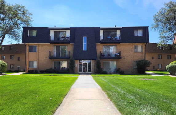 Front view of a multi-story apartment building with balconies.