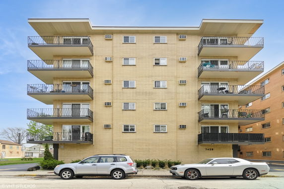 Front view of a multi-story apartment building with balconies.