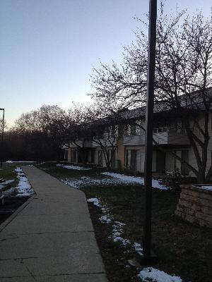View of a row of two-story houses with a pathway and some snow on the ground.