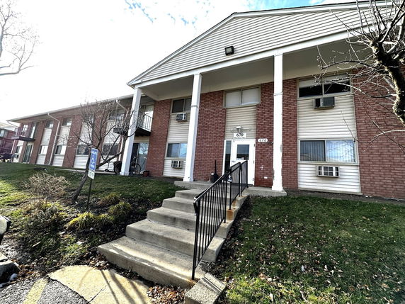 Front view of a two-story apartment building with brick and siding exterior.