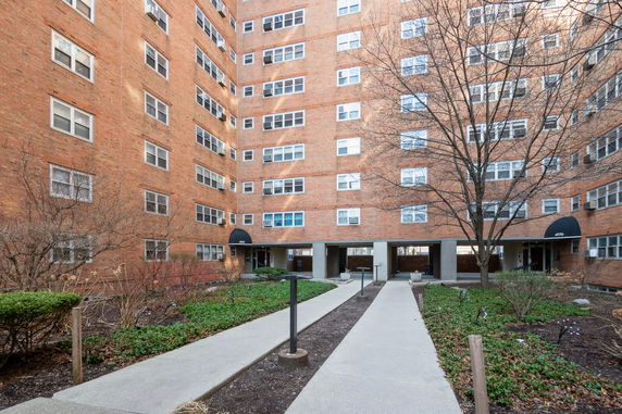 Front view of a multi-story brick building with multiple windows.