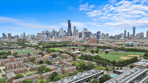 Panoramic view of a city skyline with multiple tall buildings and green areas.