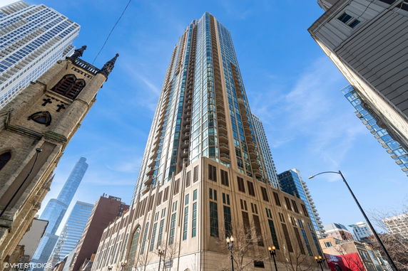 Front view of a tall modern skyscraper with glass balconies.
