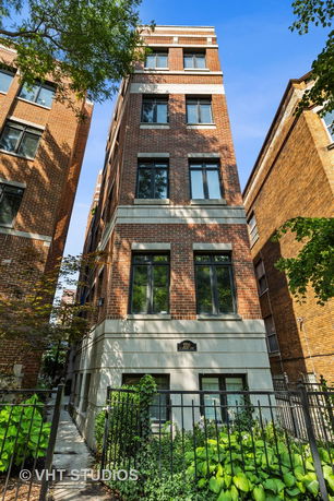 Front view of a multi-story brick building with multiple windows.
