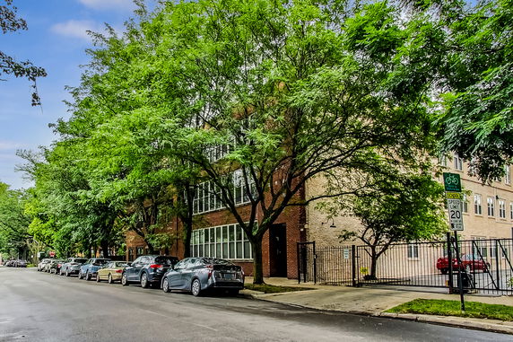 Front view of a multi-story brick building with large windows facing the street.