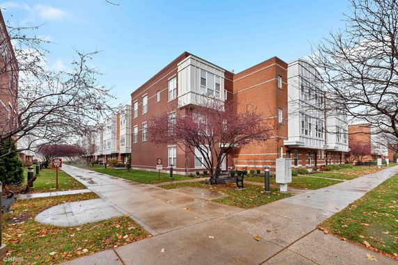 Front view of a modern multi-story brick building with large windows.