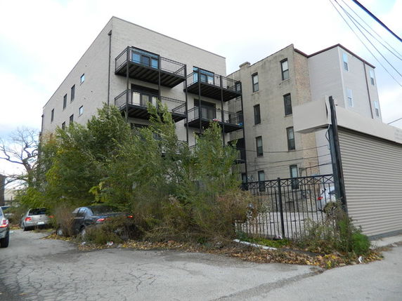 Rear view of a multi-story building with balconies.
