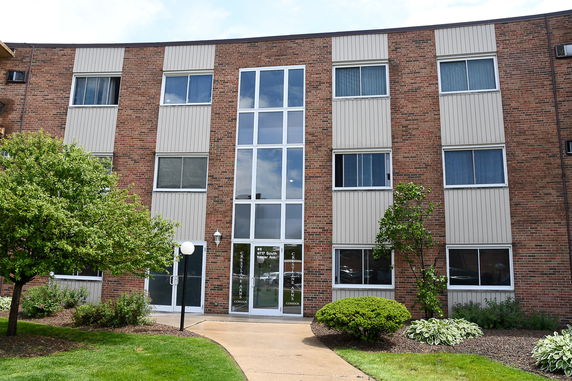 Front view of a three-story brick building with large windows.