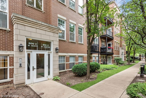Front view of a multi-story brick apartment building with balconies.